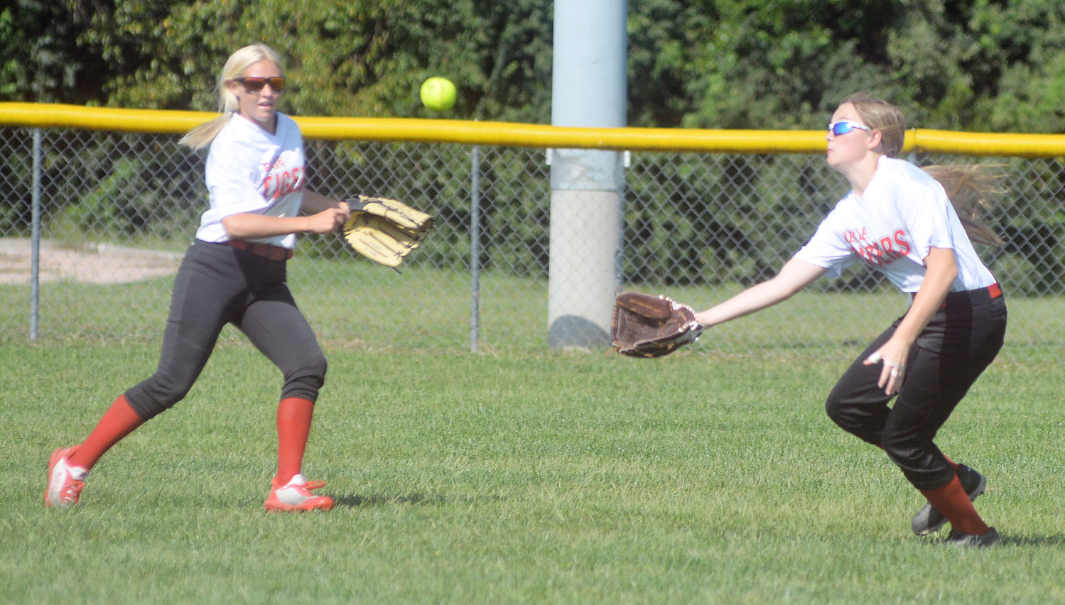 Tajel McDaniel (right) watches a sinking line drive fall into her glove while fellow Belle Lady Tiger outfielder Ileana Sullinger gets ready to back the play up in the outfield.